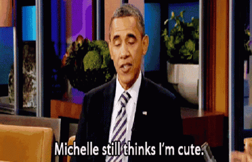 a man in a suit and tie is talking to michelle still thinks i 'm cute