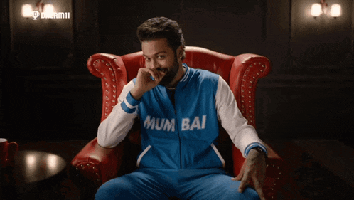 a man wearing a blue and white jacket that says mumbai