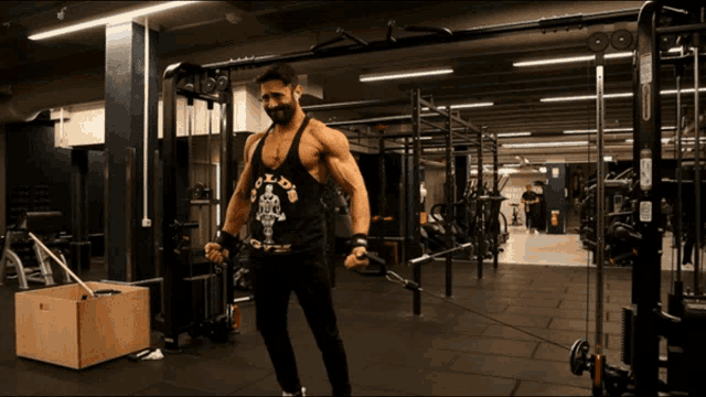 a man wearing a black tank top that says gold 's gym