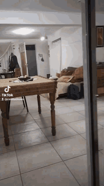 a tik tok video of a living room with a table and a couch