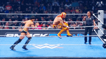 two wrestlers are in a wrestling ring with a w logo on the floor