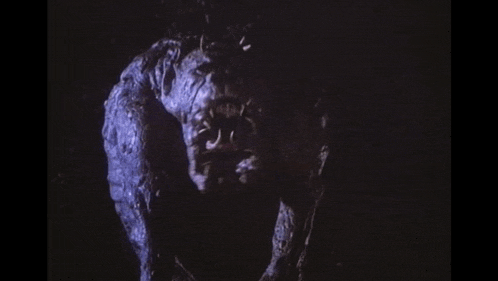 a monster is standing in the dark and looking at the camera with its mouth open