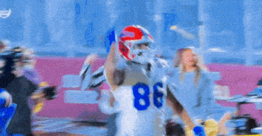 a football player with the number 86 on his jersey is catching a ball