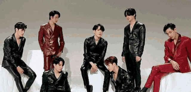a group of men in leather suits are standing next to each other on a white surface .