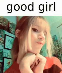 a girl is making a funny face with her hands on her chin and the words `` good girl '' written above her .