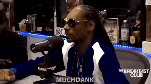 snoop dogg is sitting in front of a microphone and says muchdank