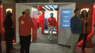 a man in a red jacket with a shell logo on it