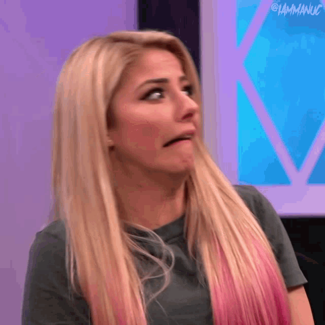 a woman with long blonde hair is making a funny face .