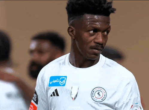 a soccer player wears a white shirt with a blue sticker that says ' aefan club ' on it