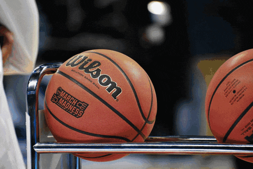 a wilson march madness basketball sits on a metal rack