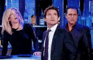 three people are standing in front of a bar looking up