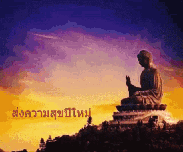 a statue of a buddha sitting on top of a hill with a sunset in the background and a foreign language written below