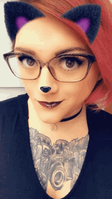 a woman wearing cat ears and glasses looks at the camera