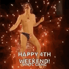 a shirtless man in american flag underwear is dancing on a stage with fireworks in the background .