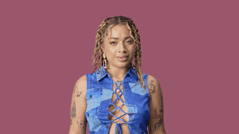 a woman in a blue shirt is standing in front of a pink background that says no