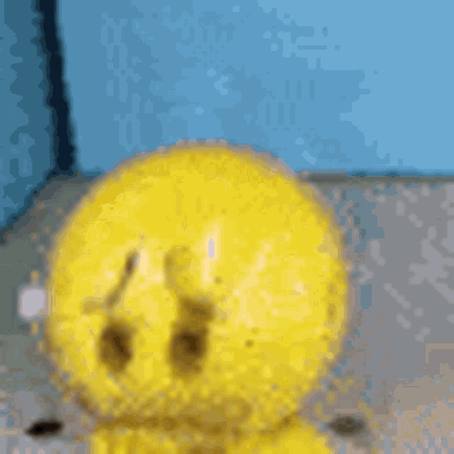 a close up of a yellow smiley face sitting on a table .