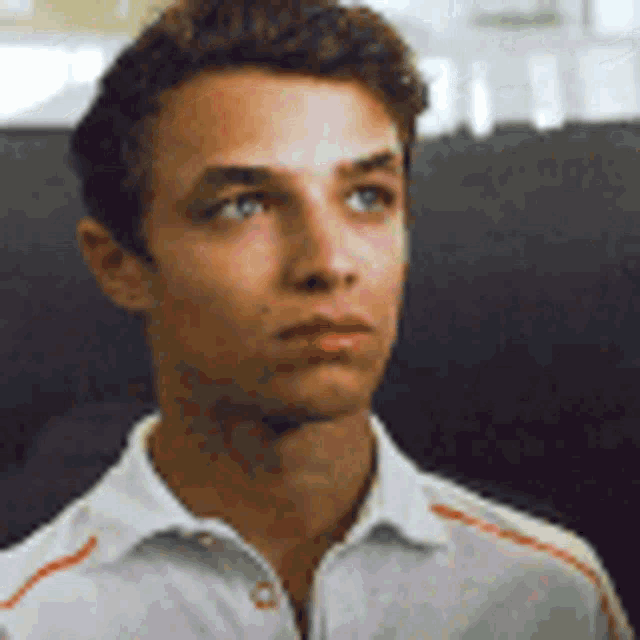 a young man in a white shirt is looking at something .