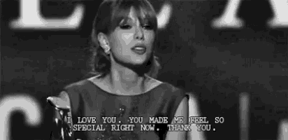 a black and white photo of taylor swift giving a thumbs up while holding a trophy .
