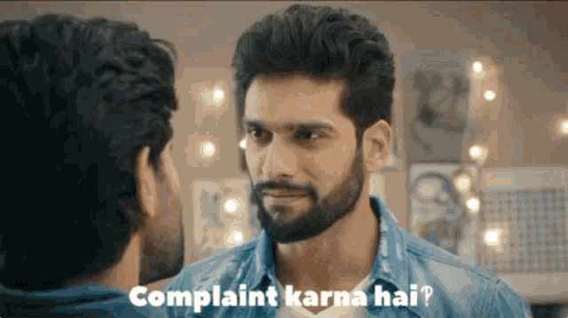 a man with a beard is talking to another man with the words " complaint karna hai " written below him