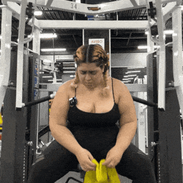 a woman sits on a machine with a sign that says aviso on it