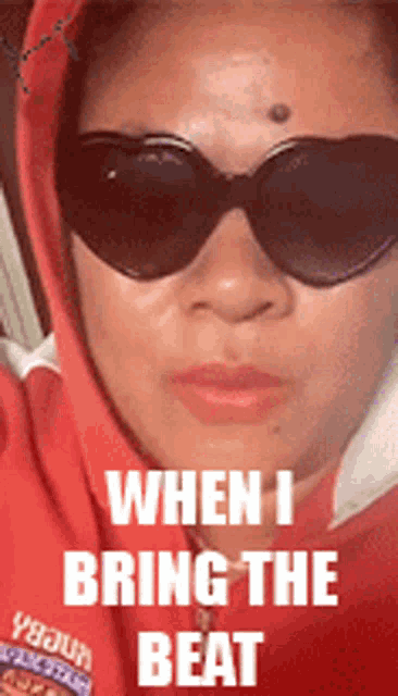 a woman wearing sunglasses and a red hoodie with the words " when i bring the beat " on the bottom