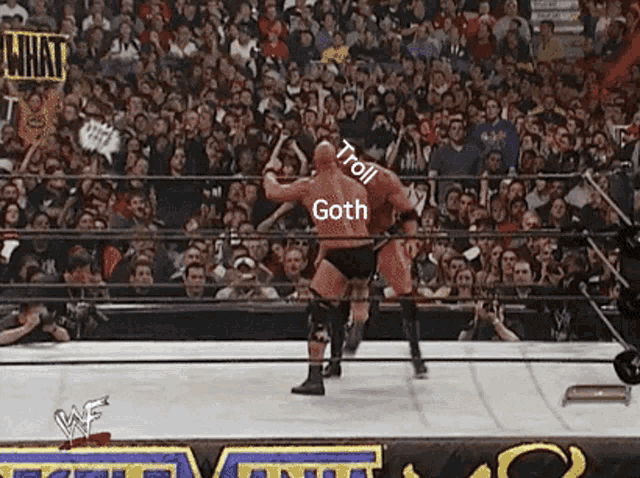 a man in a red shirt is wrestling another man in a black shirt in a wrestling ring .