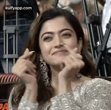 a woman is making a funny face with her hands .
