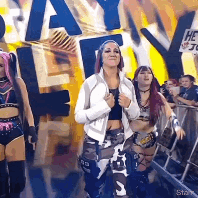 a group of women are standing in front of a sign that says slay