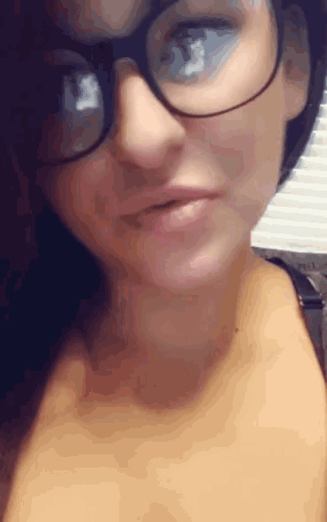 a close up of a woman wearing glasses making a funny face