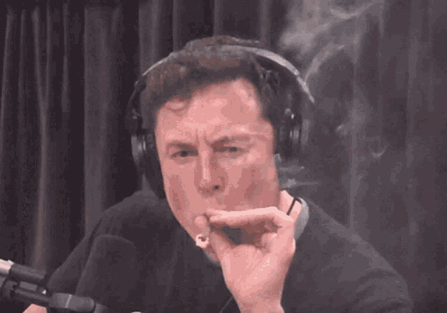 a man wearing headphones and smoking a cigarette