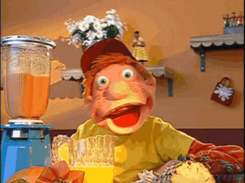 a puppet is holding a glass of orange juice