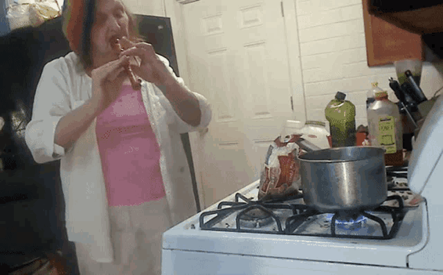 a woman playing a flute in a kitchen with a bottle of tonic in the background