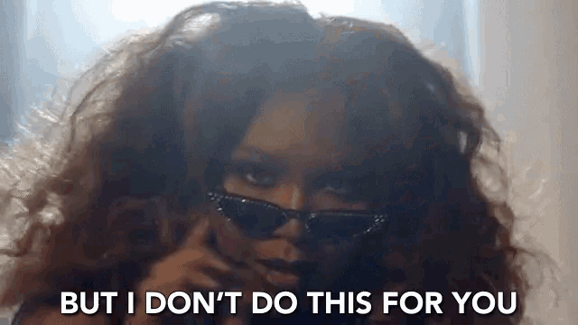 a woman wearing sunglasses is talking on a cell phone .