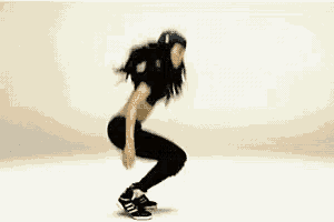 a woman is jumping in the air while wearing a hat and a crop top .