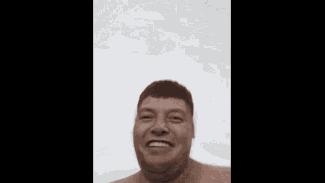 a shirtless man is making a funny face and smiling