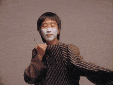 a person with a white face and a striped shirt