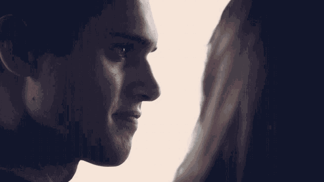 a close up of a man 's face with a woman behind him