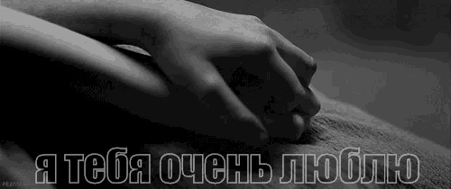 a black and white photo of a person holding another person 's hand with the words " i love you " in russian