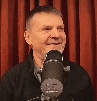 a man is smiling in front of a microphone with the word absolutt on it .