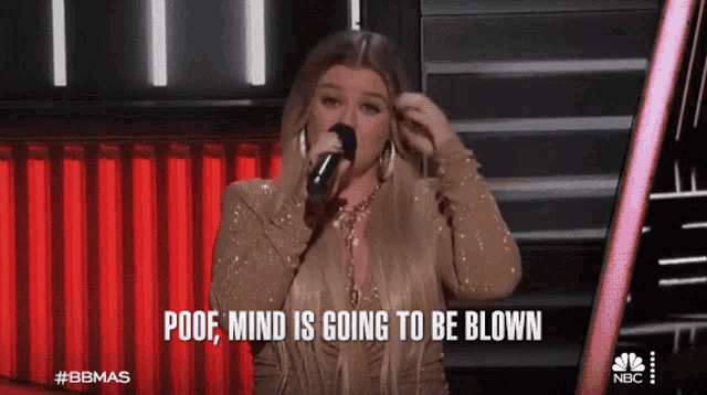 a woman singing into a microphone with the words poof mind is going to be blown below her