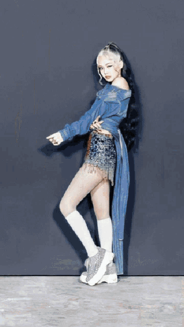 a woman wearing a blue jacket and white socks is dancing
