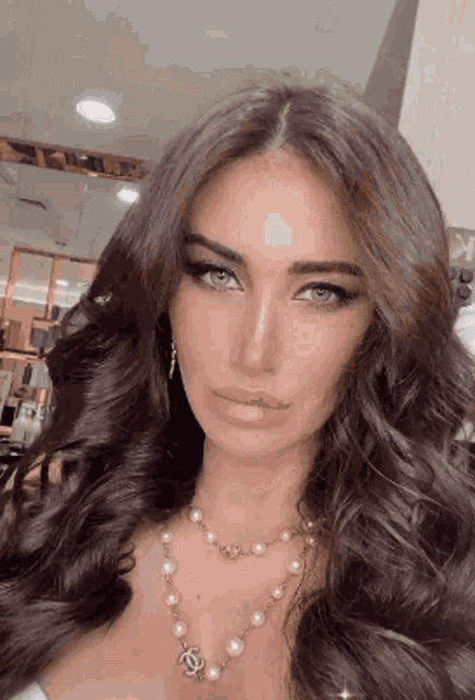 the woman is wearing a pearl necklace and earrings