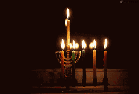 a menorah with many lit candles and the word gifmania on the bottom