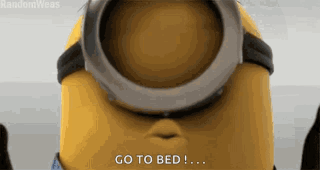 a close up of a minion wearing goggles saying go to bed !
