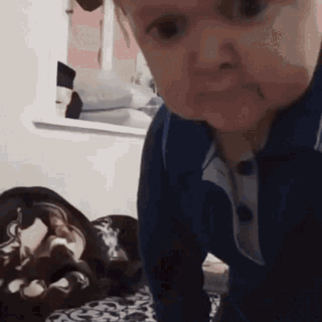 a baby is crawling on a bed and making a face