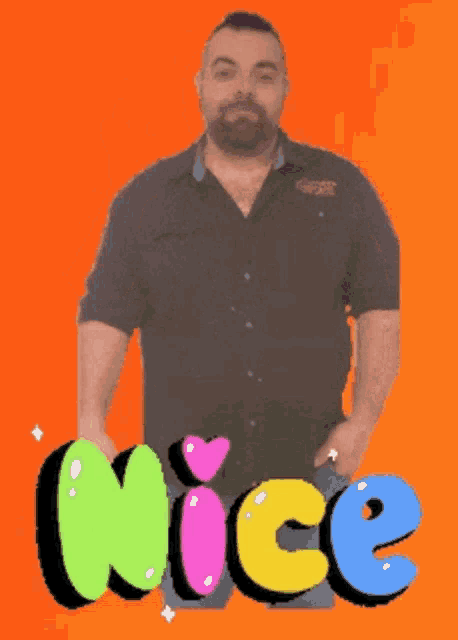 a man with his hands in his pockets stands in front of a nice sign
