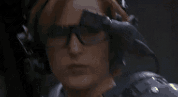 a close up of a person holding a gun in a dark room with a lot of smoke coming out of it .