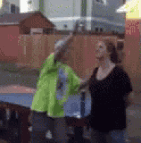 a man in a neon green shirt is standing next to a woman in a black shirt
