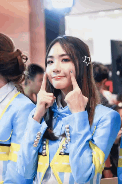 a girl in a blue and yellow jacket with a star on her hair