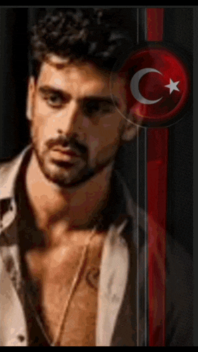 a man with a beard is standing in front of a flag with a crescent moon and star